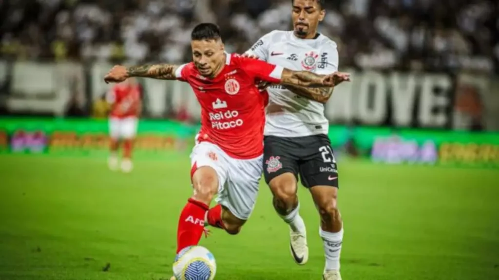 Dois homens jogando futebol em um campo